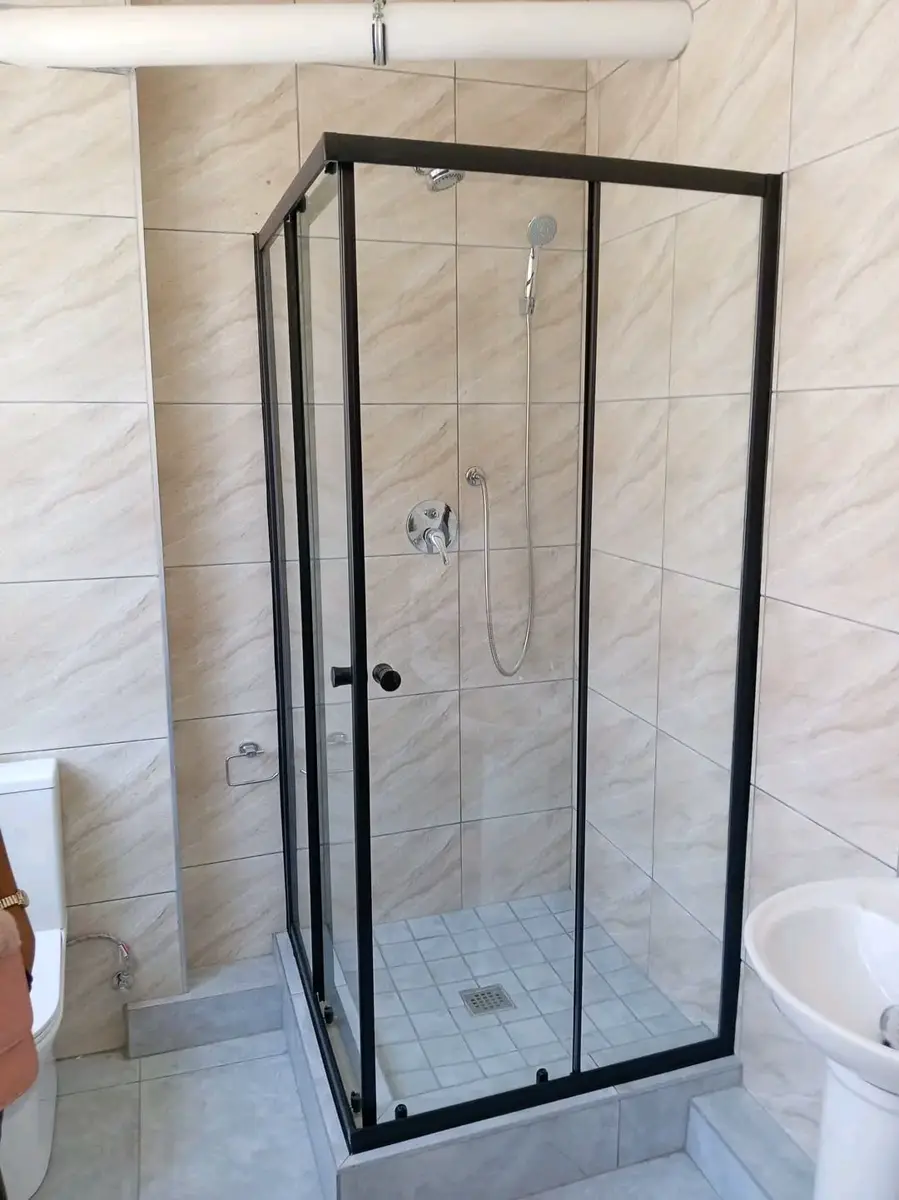 Walk-in glass shower in a tiled bathroom