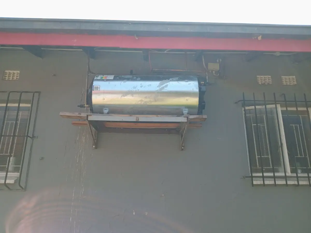 Weathered building facade with a central rooftop solar water heater